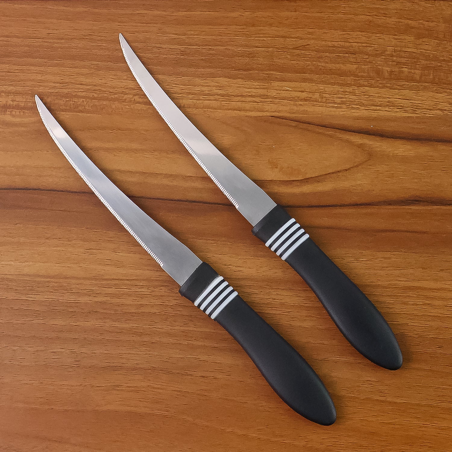 Wukusy premium curved serrated stainless steel kitchen knife set with two colorful knives on a wooden cutting board.