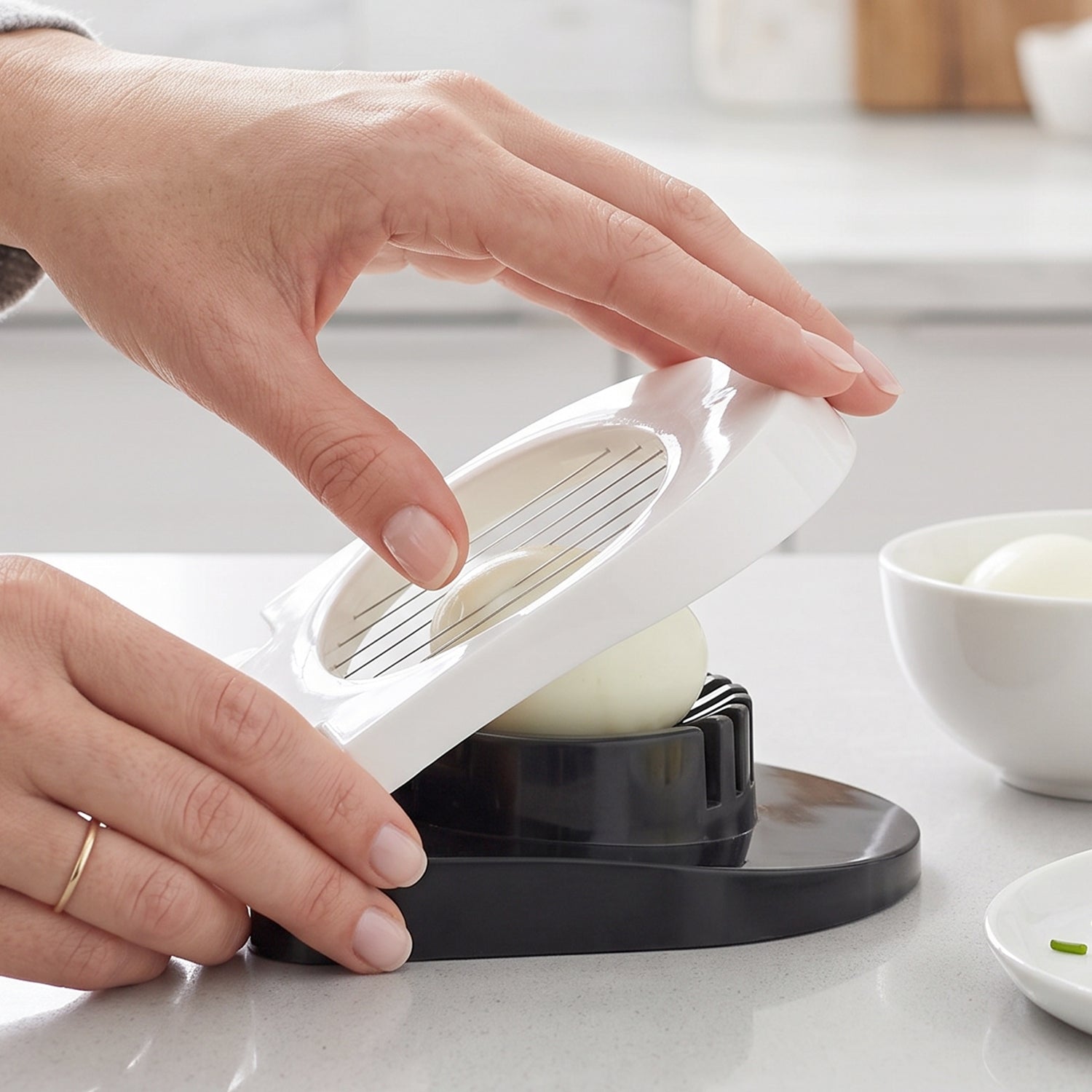 Wukusy stainless steel egg cutter slicer with wire blades for neatly slicing boiled eggs on a white surface.