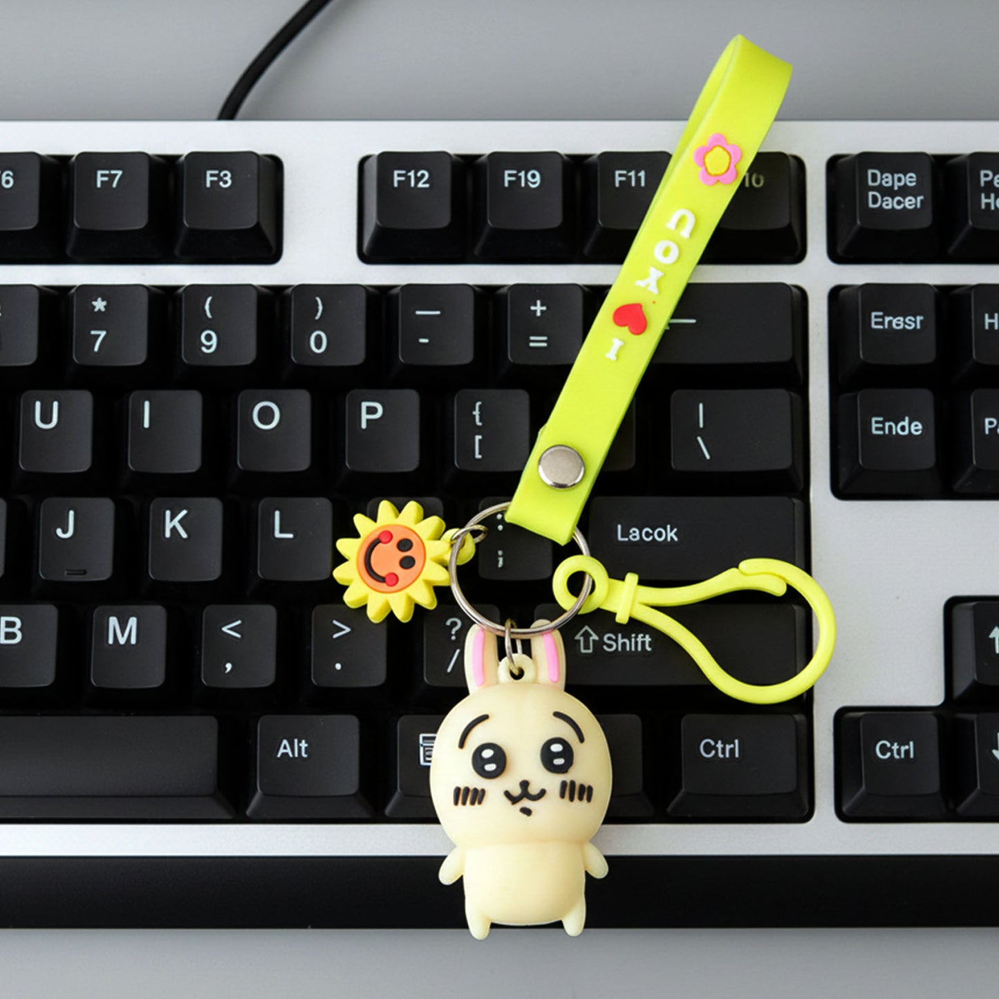 Cute Wukusy cartoon bunny silicone keychain with decorative strap, featuring a colorful bunny design and adjustable strap.