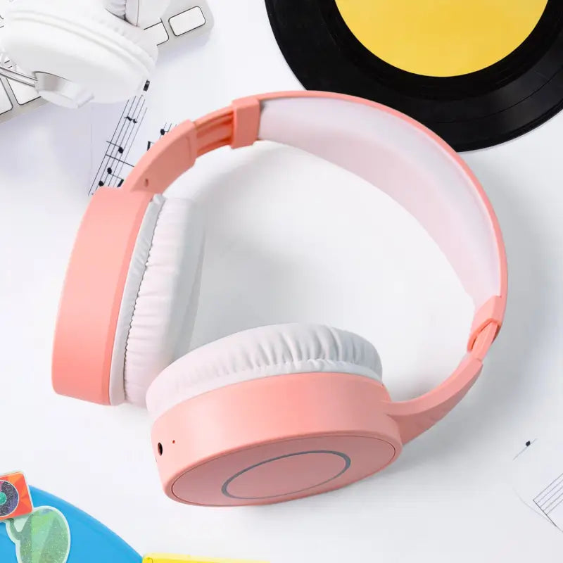 Ekom wireless over-ear Bluetooth headphones with cushioned earmuffs, foldable design, built-in mic, and compact size.