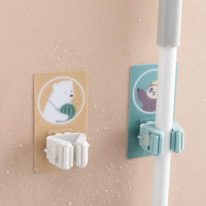 Wukusy 1633 Magic Sticker Series self-adhesive mop and broom holder mounted on a wall for home organization.