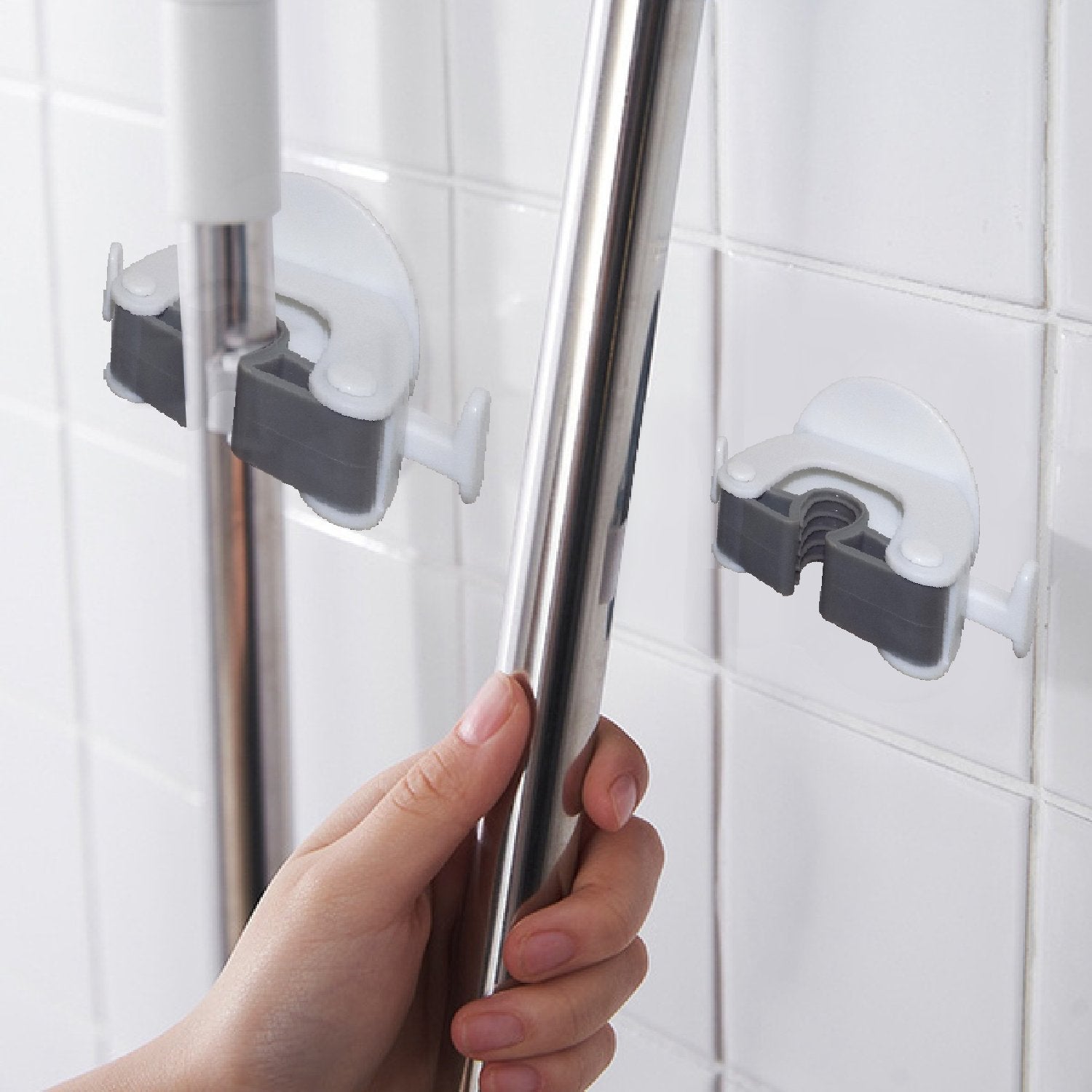 Wukusy 1670 Mop and Broom Holder mounted on wall, holding cleaning tools with hooks and secure clips.