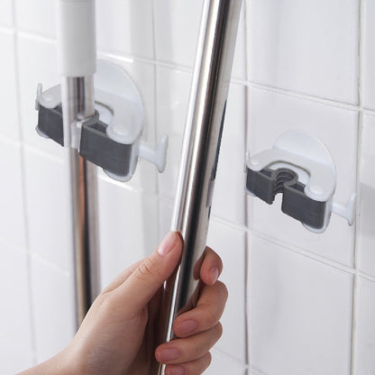 Wukusy 1670 Mop and Broom Holder mounted on wall, holding cleaning tools with hooks and secure clips.