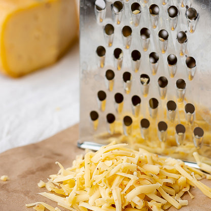 Wukusy Apex Classic 4-in-1 stainless steel grater and slicer with handle for versatile kitchen use, showing multiple blade options.