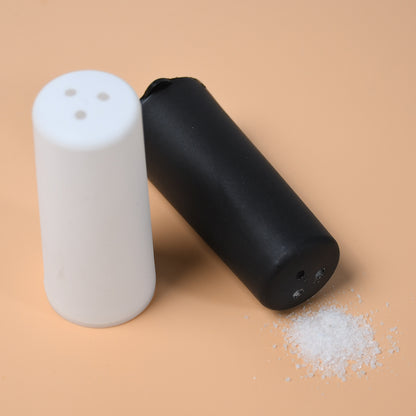 Wukusy salt and pepper dispenser set on a dining table, designed for home and hotel use for spice storage and seasoning.