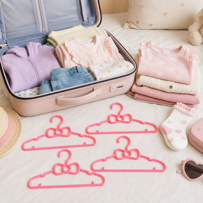 Set of four Wukusy kids plastic clothes hangers with cute bow designs, ideal for baby wardrobes and children's clothing organization.