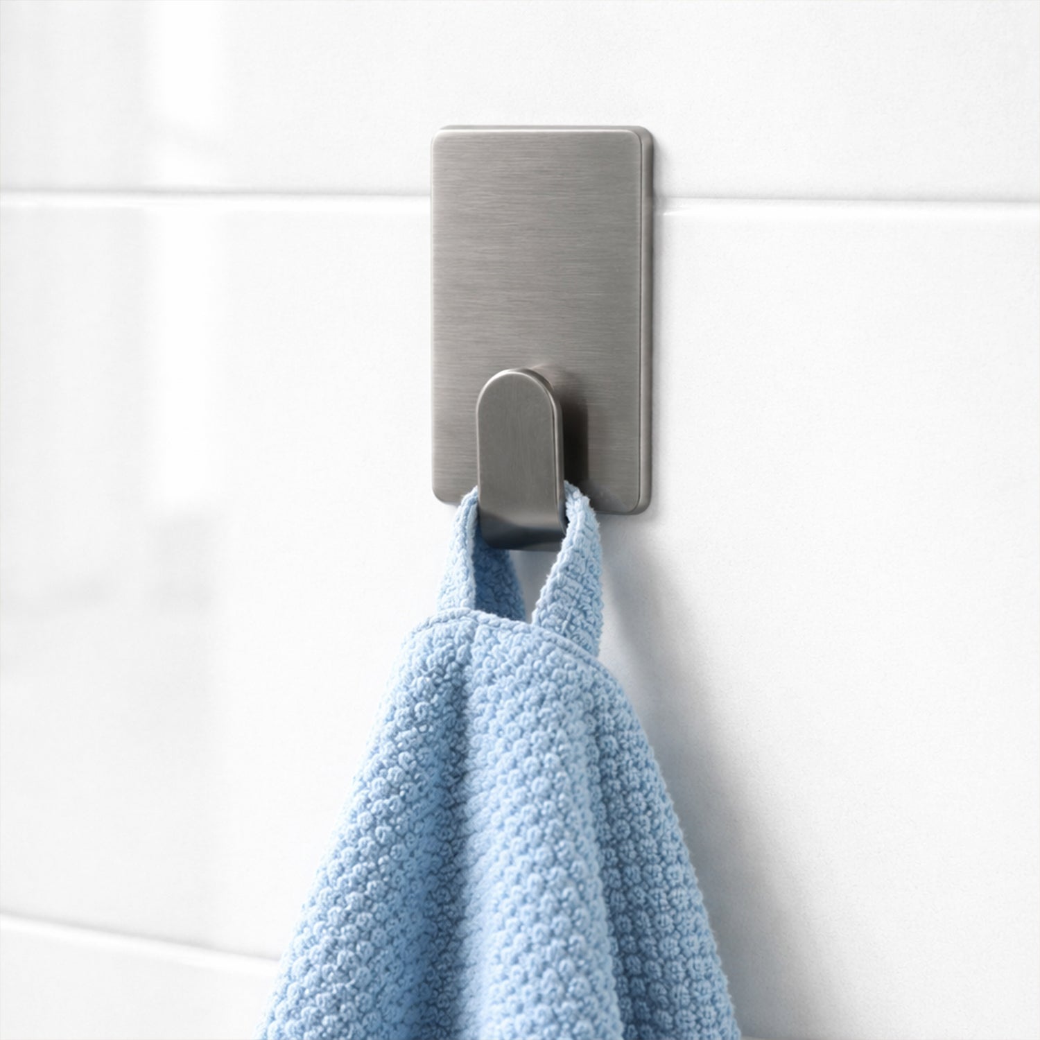 Set of six Wukusy self-adhesive wall hooks mounted on a wall for hanging items, showing their sleek and practical design.