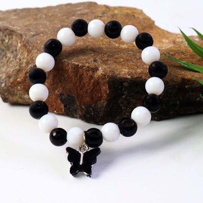 Elegant black and white fancy bracelet by Wukusy featuring intricate design and stylish accents, displayed on a neutral background.