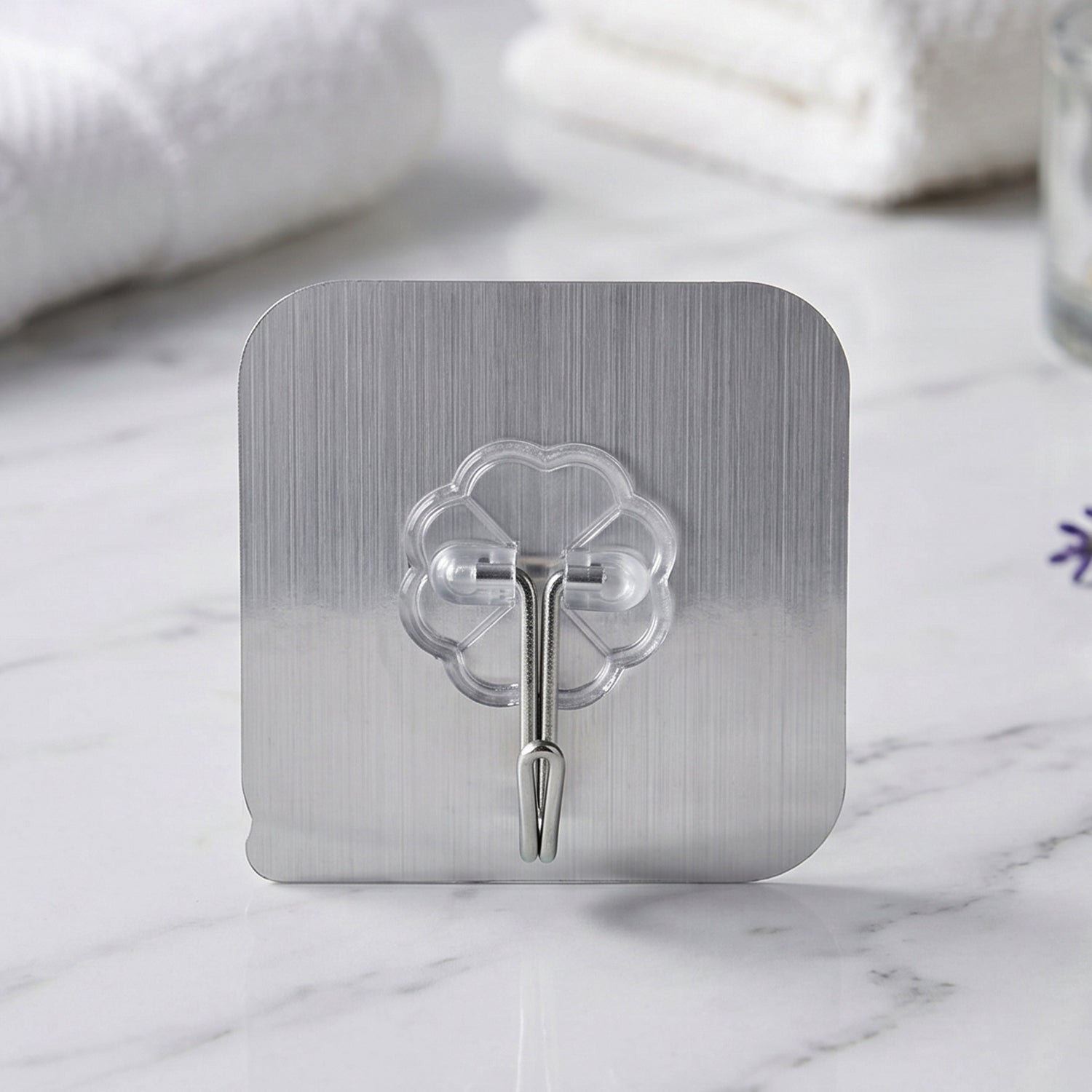 Transparent heavy-duty self-adhesive wall hook by Wukusy, showing a close-up of the clear hook attached to a wall surface.