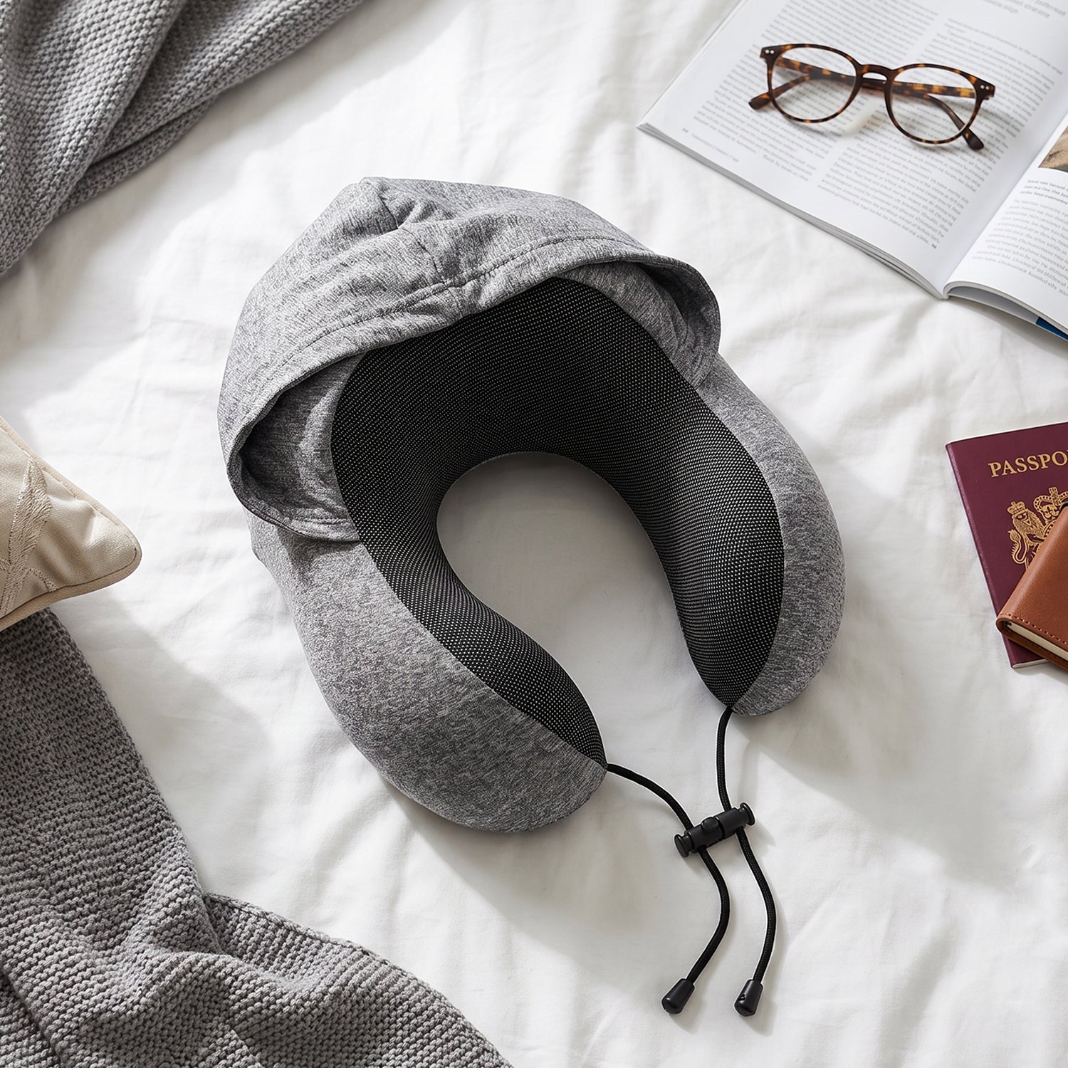 Grey U-shaped Wukusy travel neck pillow with hood and drawstring for neck support and comfort during travel or rest.