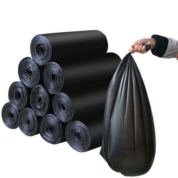 Black medium-sized Wukusy garbage bags, 24x32 inches, shown in a natural outdoor setting for waste disposal use.