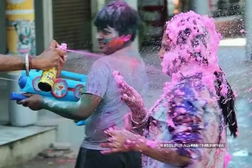 Two bottles of Cock Brand Colour Snow Spray in multicolor for party decoration, creating festive snow effects.