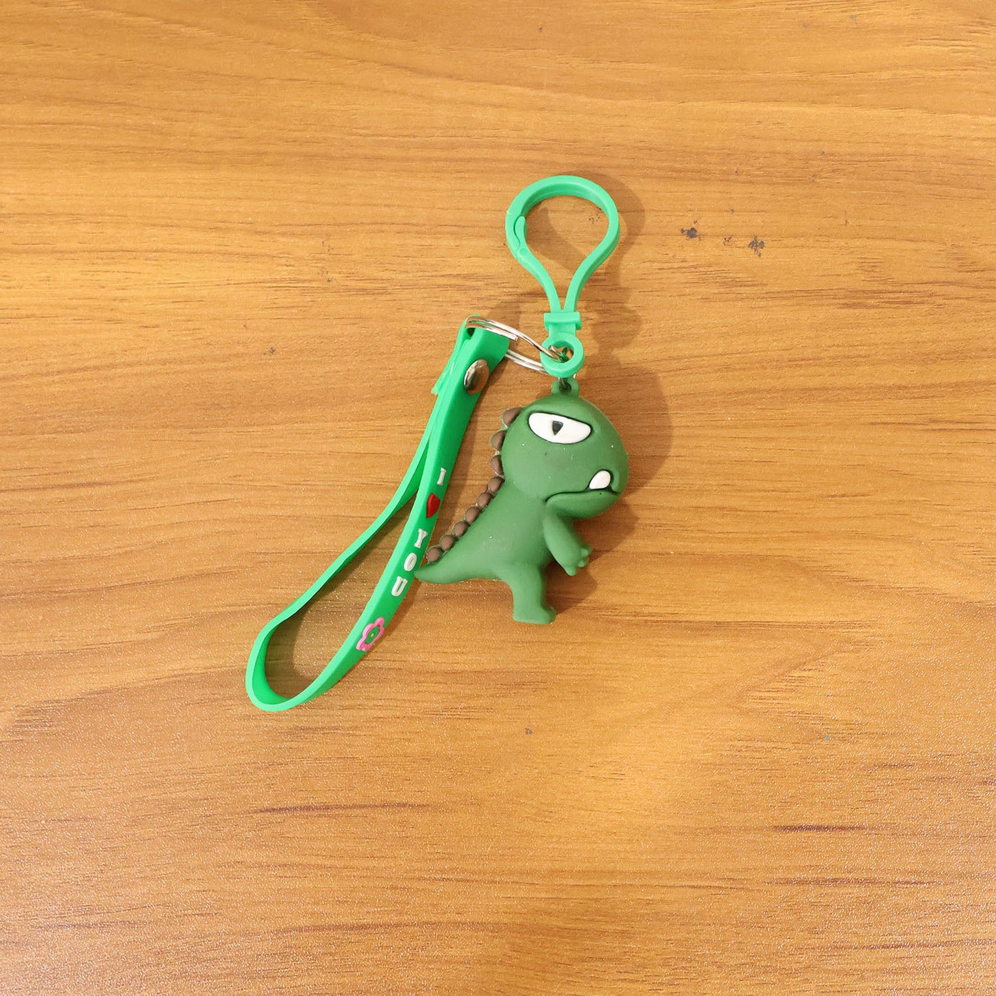 Cute dinosaur cartoon silicone keychain by Wukusy featuring a colorful dinosaur design on a keyring.