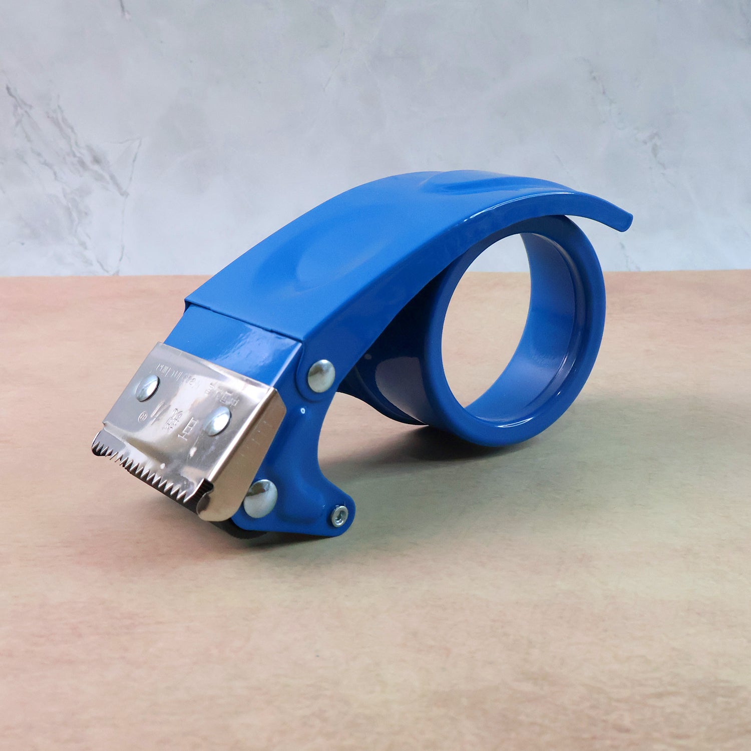 Wukusy heavy-duty tape dispenser cutter with ergonomic handle and metal cutting blade, shown on a flat surface.