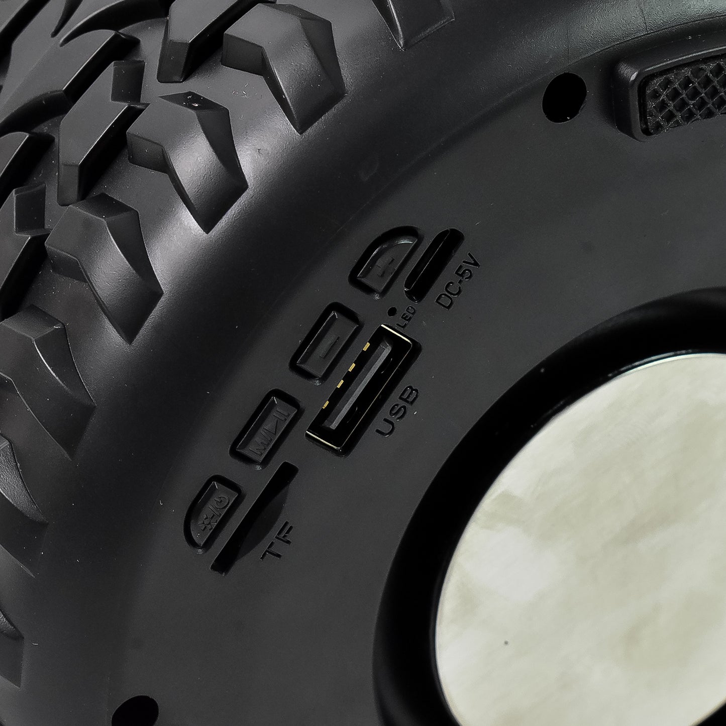 Wukusy portable wireless Bluetooth speaker shaped like a tyre wheel, compact mobile accessory with control buttons visible.