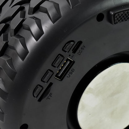 Wukusy portable wireless Bluetooth speaker shaped like a tyre wheel, compact mobile accessory with control buttons visible.