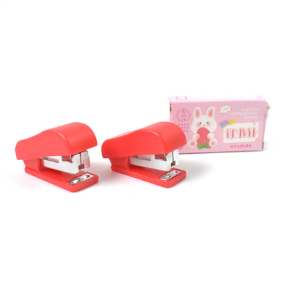 Wukusy mini office stapler with staples and pin set, compact and portable for quick stapling tasks in an office setting.