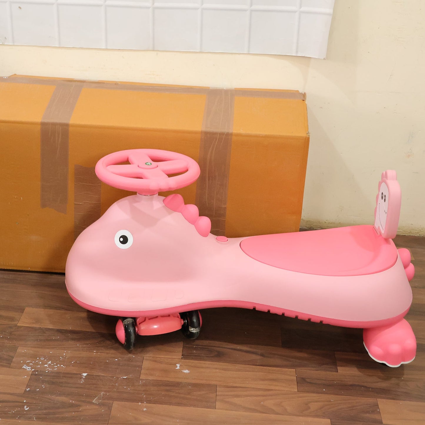 Pink shark-shaped kids swing car ride-on toy by Wukusy with music, featuring a colorful twist design for children to play and ride.