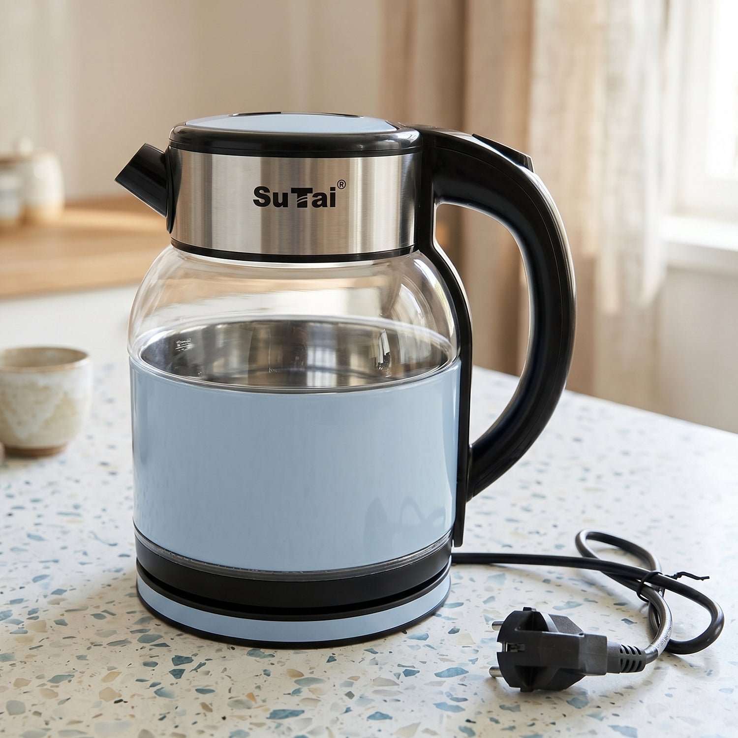 Wukusy Suta electric glass kettle with 2-liter stainless steel body, clear glass design, and water level indicator.
