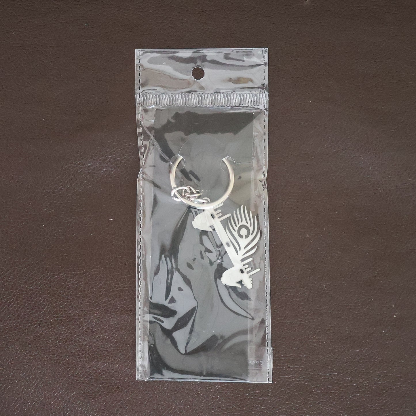 Wukusy Krishna Flute peacock feather metal keychain, decorative accessory with intricate design and vibrant feather detail.