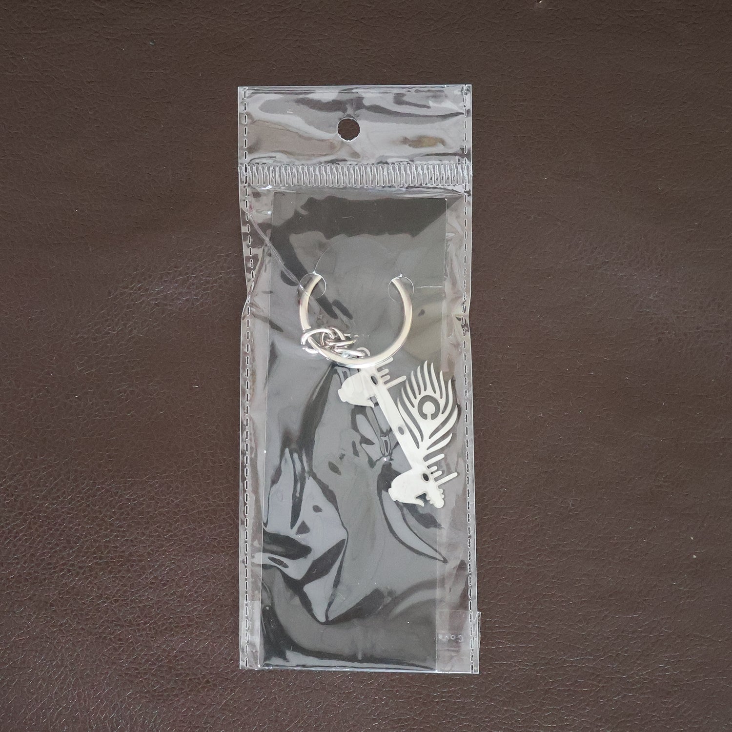 Wukusy Krishna Flute peacock feather metal keychain, decorative accessory with intricate design and vibrant feather detail.