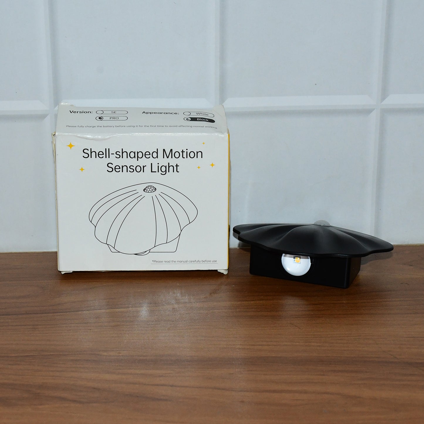 Wukusy shell-shaped motion sensor night light as a home decor accessory, with a sleek design and soft illumination in a cozy setting.
