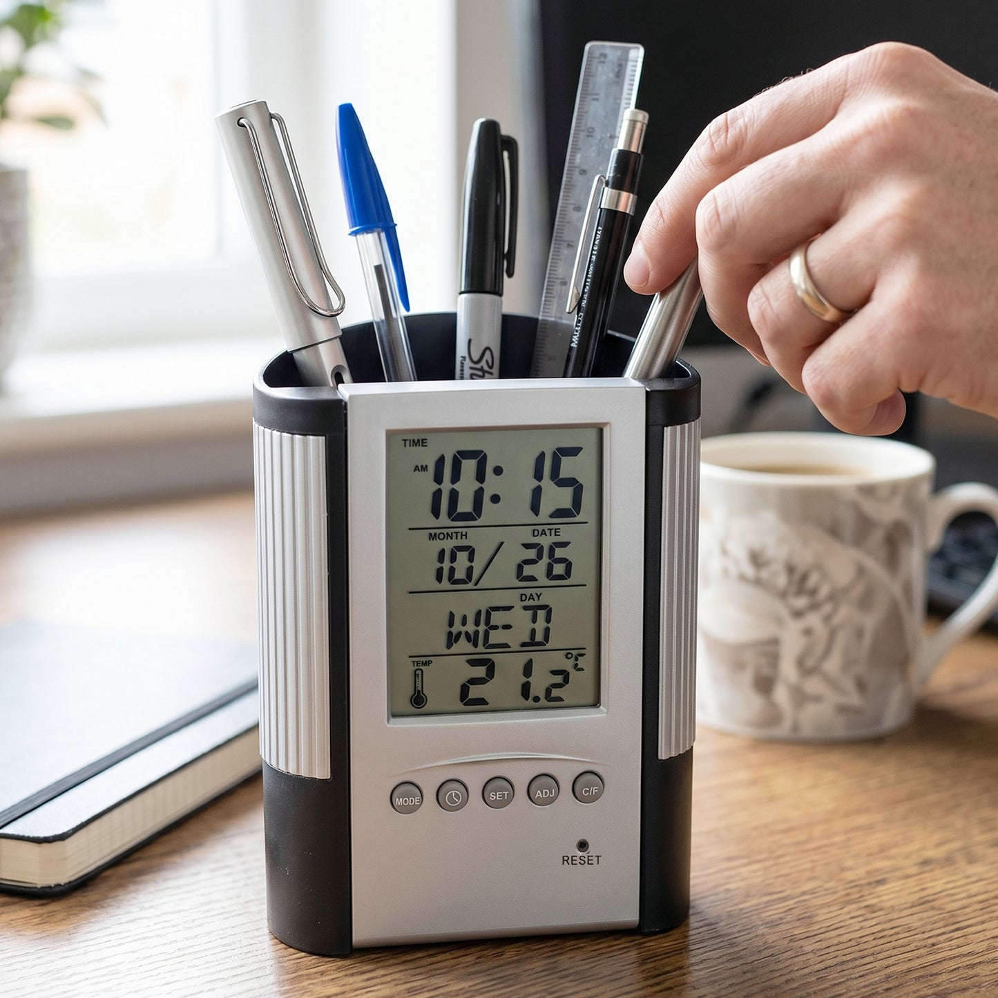 Wukusy multifunction digital calendar desk clock with pen holder on a desk, showing time and date display.