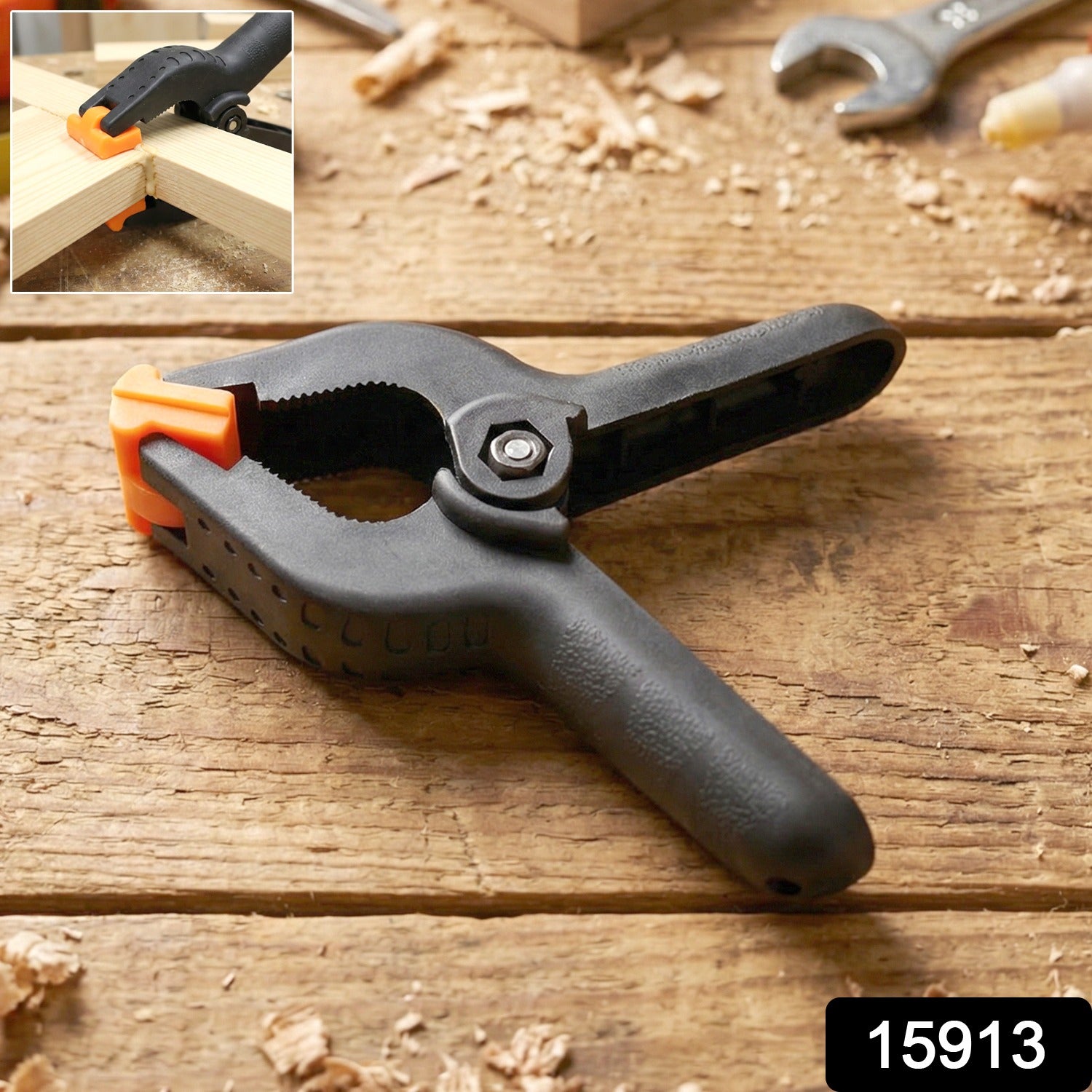 Heavy-duty Wukusy spring clamp holding materials, showcasing its strong metal jaws and ergonomic handle for secure grip.