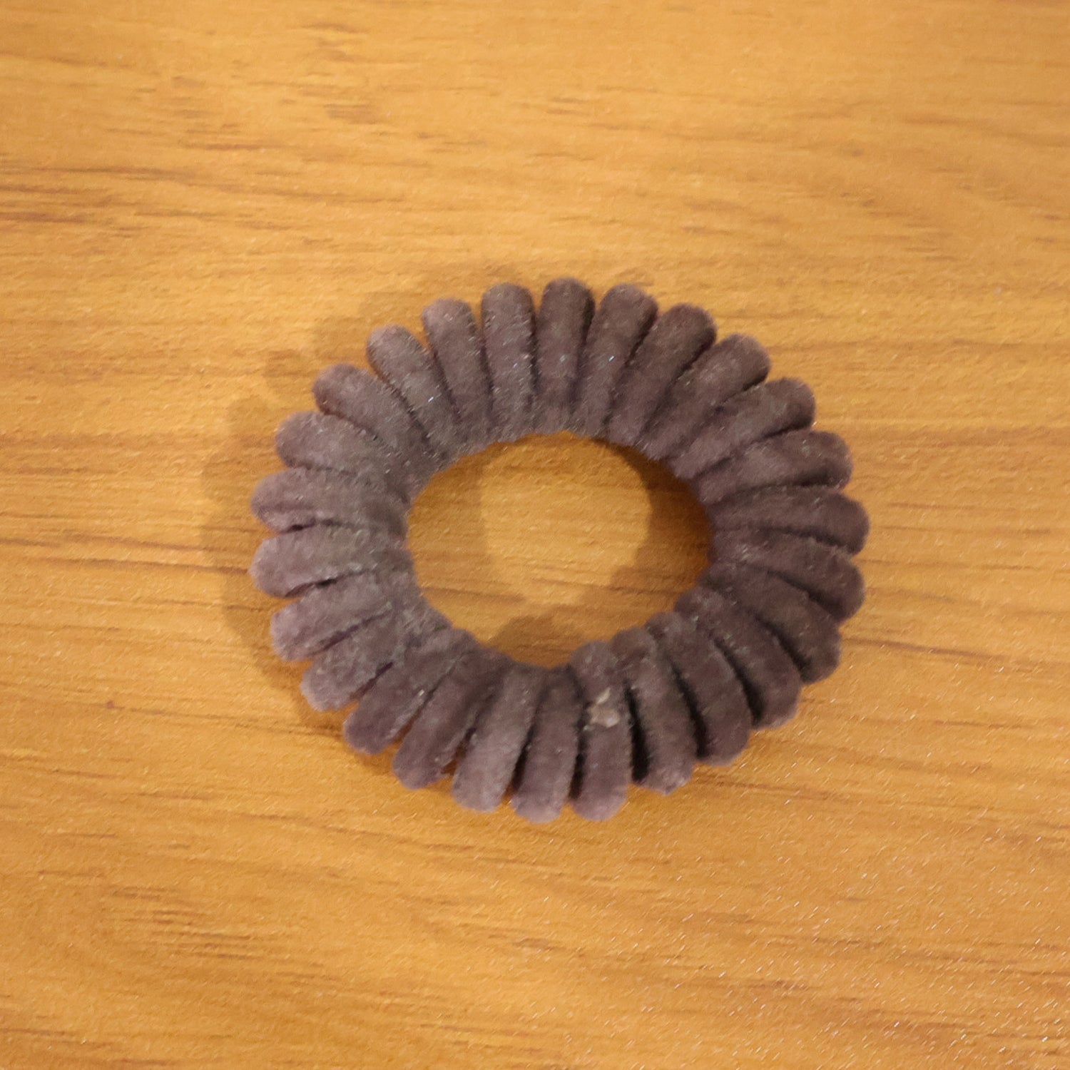 Soft stretchable telephone wire style hair band by Wukusy, shown in a close-up of the flexible, coil design on a plain background.