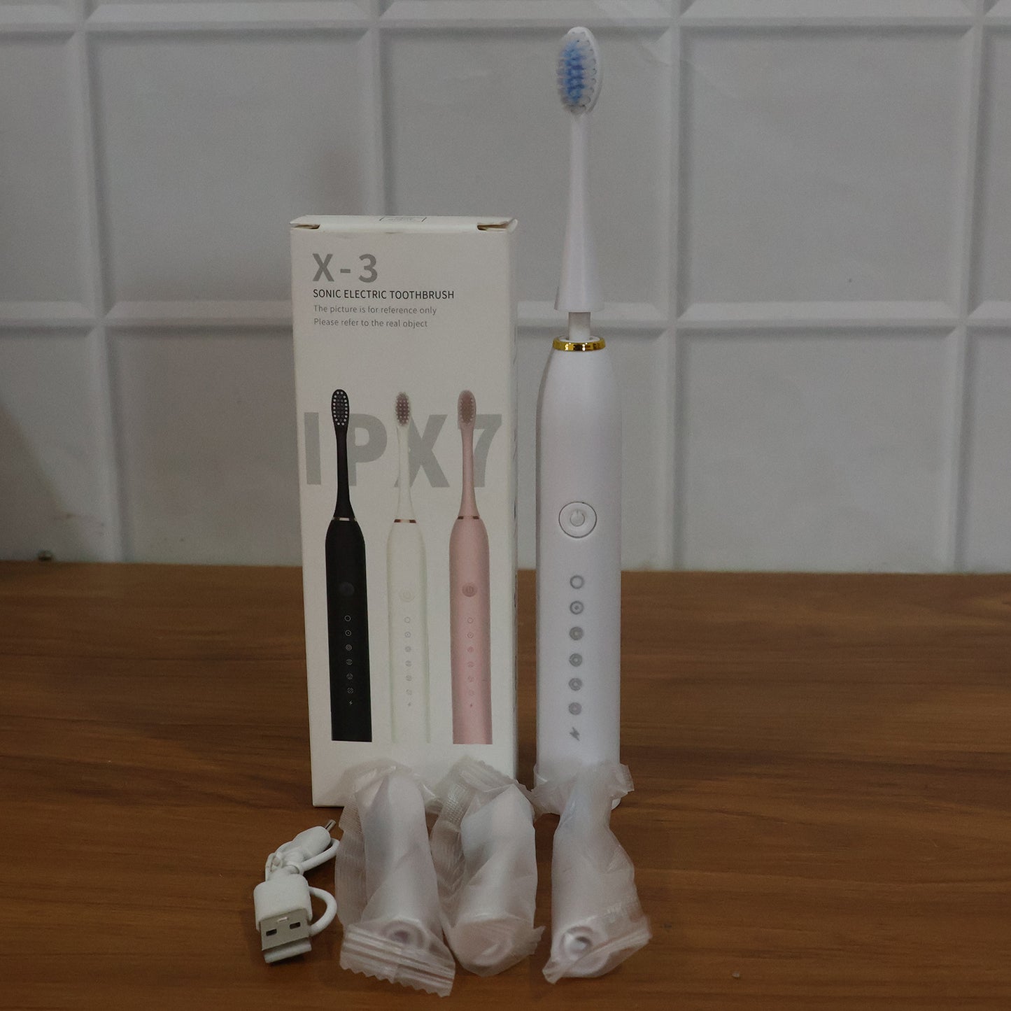 Wukusy rechargeable electric toothbrush in white with three extra brush heads, showing the toothbrush and replacement heads.