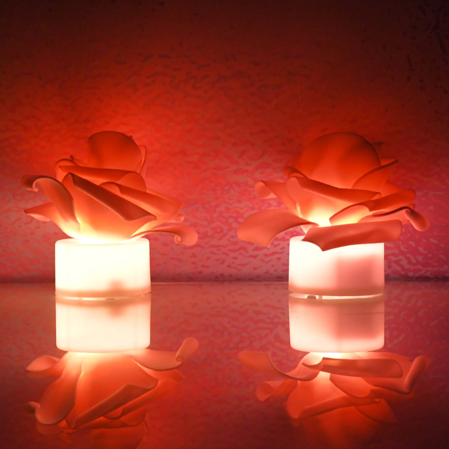 Two rose-shaped LED flickering tealight candles in a home decor setting, branded Wukusy, with warm, flickering light.