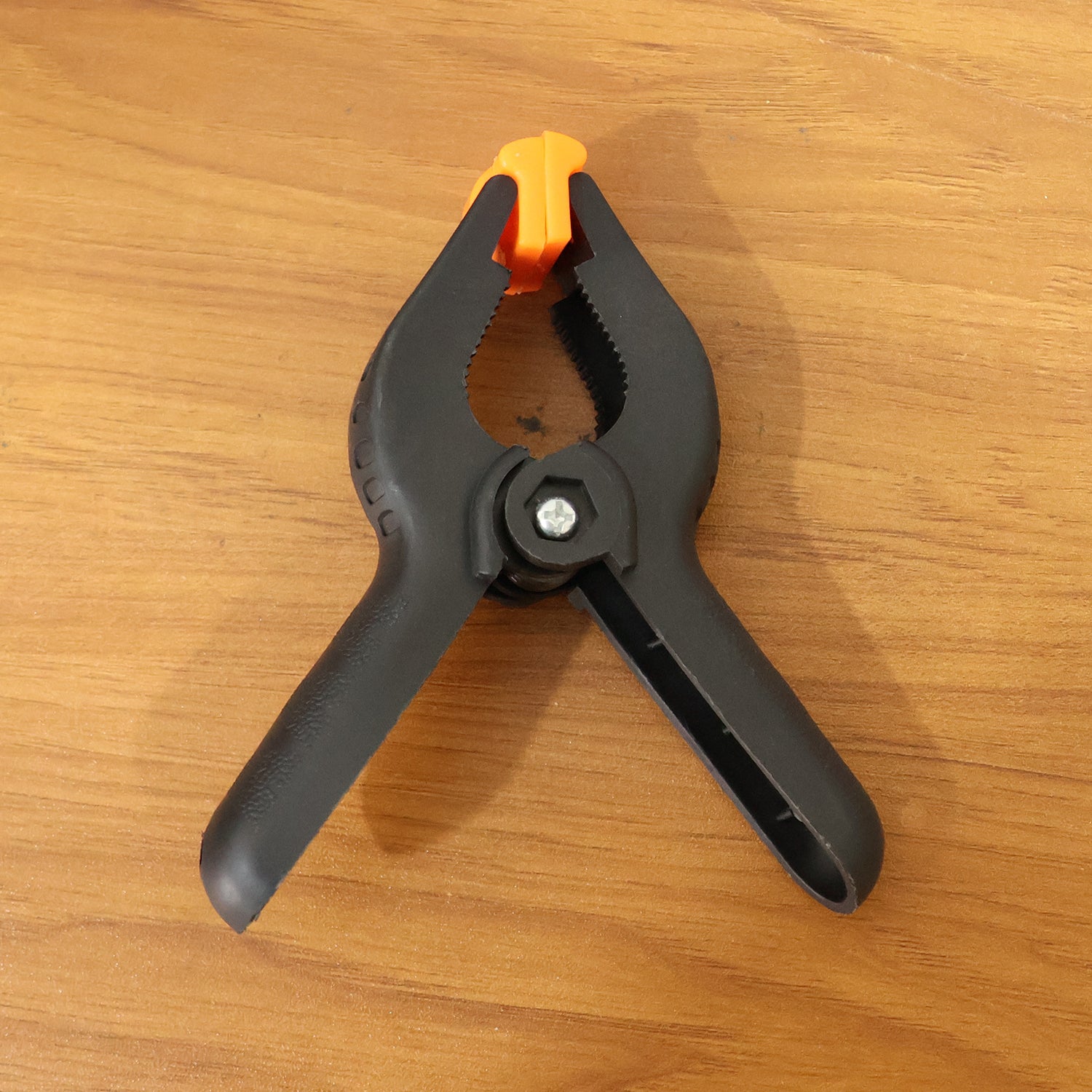 Heavy-duty Wukusy spring clamp securing objects with a metal body and strong gripping jaws for industrial use.