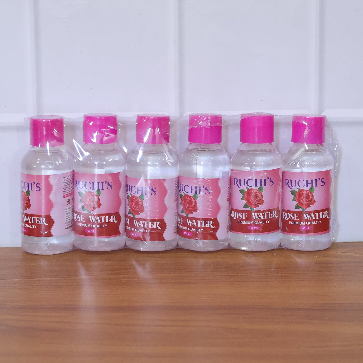 Wukusy Premium Rose Water Face Cleanser bottles, 6-pack, 100ml each, with rose petals and cleanser bottles on a clean background.