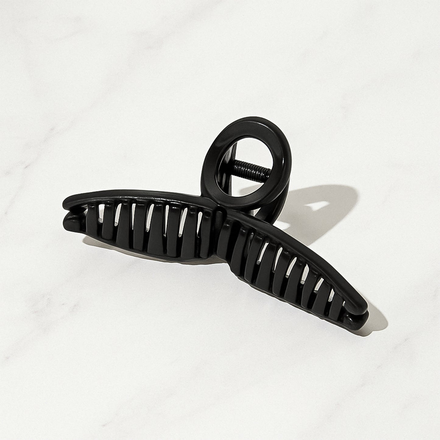 Wukusy plastic hair claw clip with strong grip, mixed design and color, shown holding hair in a natural style.