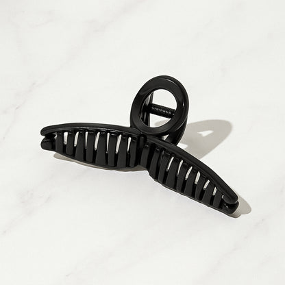 Wukusy plastic hair claw clip with strong grip, mixed design and color, shown holding hair in a natural style.