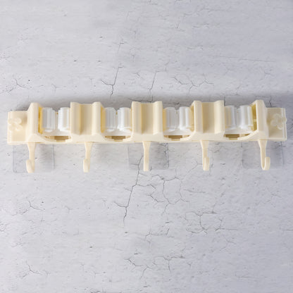 Wukusy self-adhesive wall-mount broom and mop holder rack mounted on wall for organized home cleaning tools.