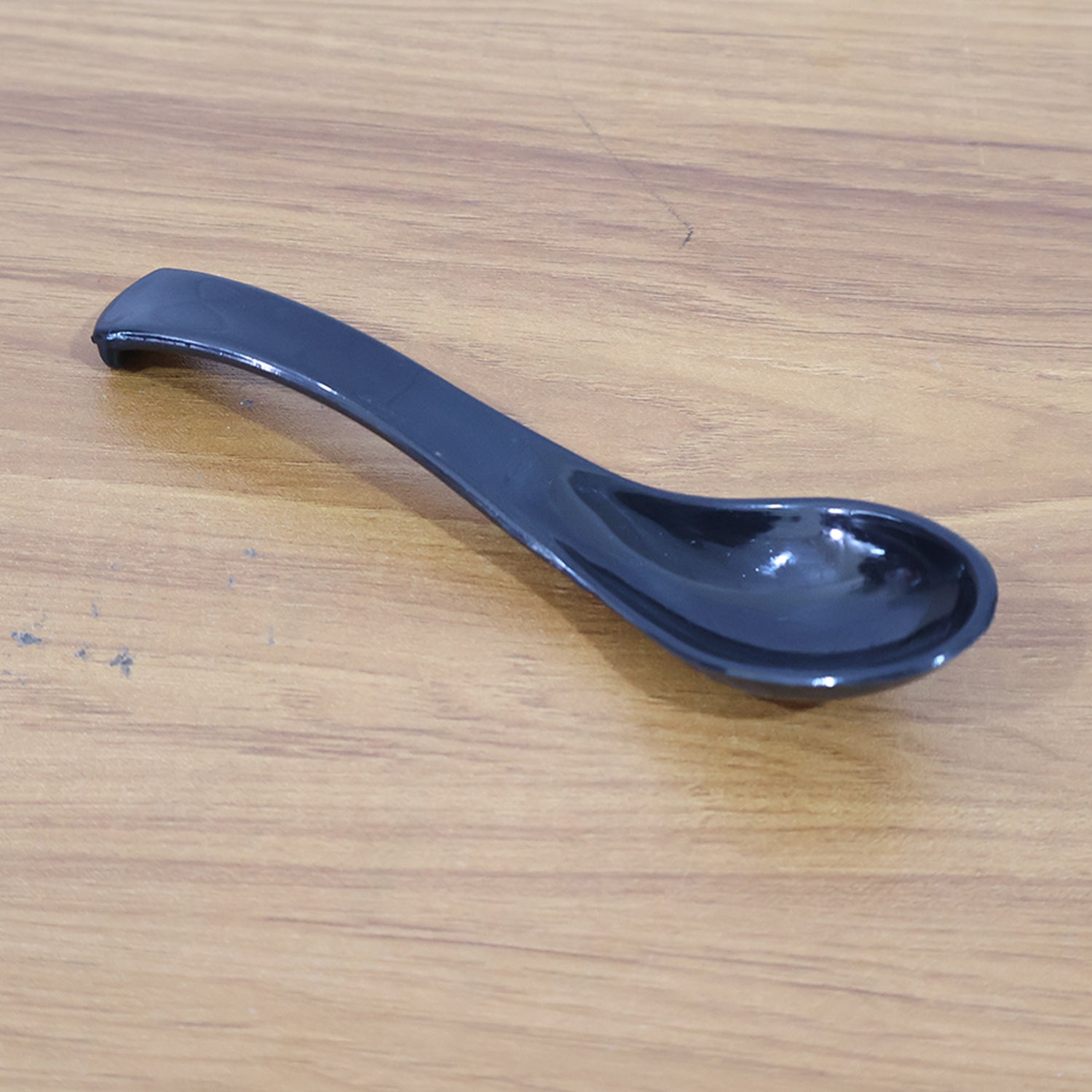 Black plastic soup spoon with deep bowl from Wukusy, ideal for serving and eating soups in home and kitchen settings.