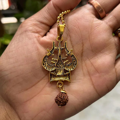 Spiritual necklace featuring Shiva Trishul and damaru, a traditional Pooja article with intricate design and religious symbolism.