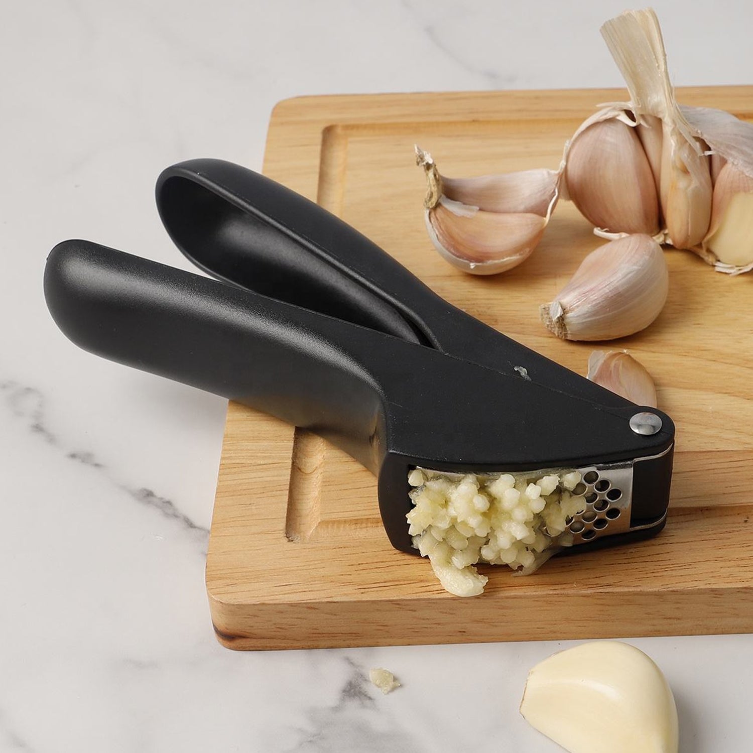 Wukusy manual garlic press crusher tool with stainless steel handles and chamber for easy garlic mincing and crushing.