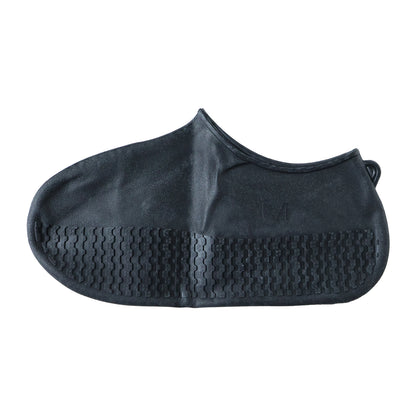 Pair of black waterproof silicone shoe covers by Wukusy, medium size, shown on a shoes in a natural outdoor setting