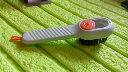 Wukusy multifunctional scrubbing brush with liquid soap dispenser, handle, and shoe cleaning brush for home cleaning tasks.