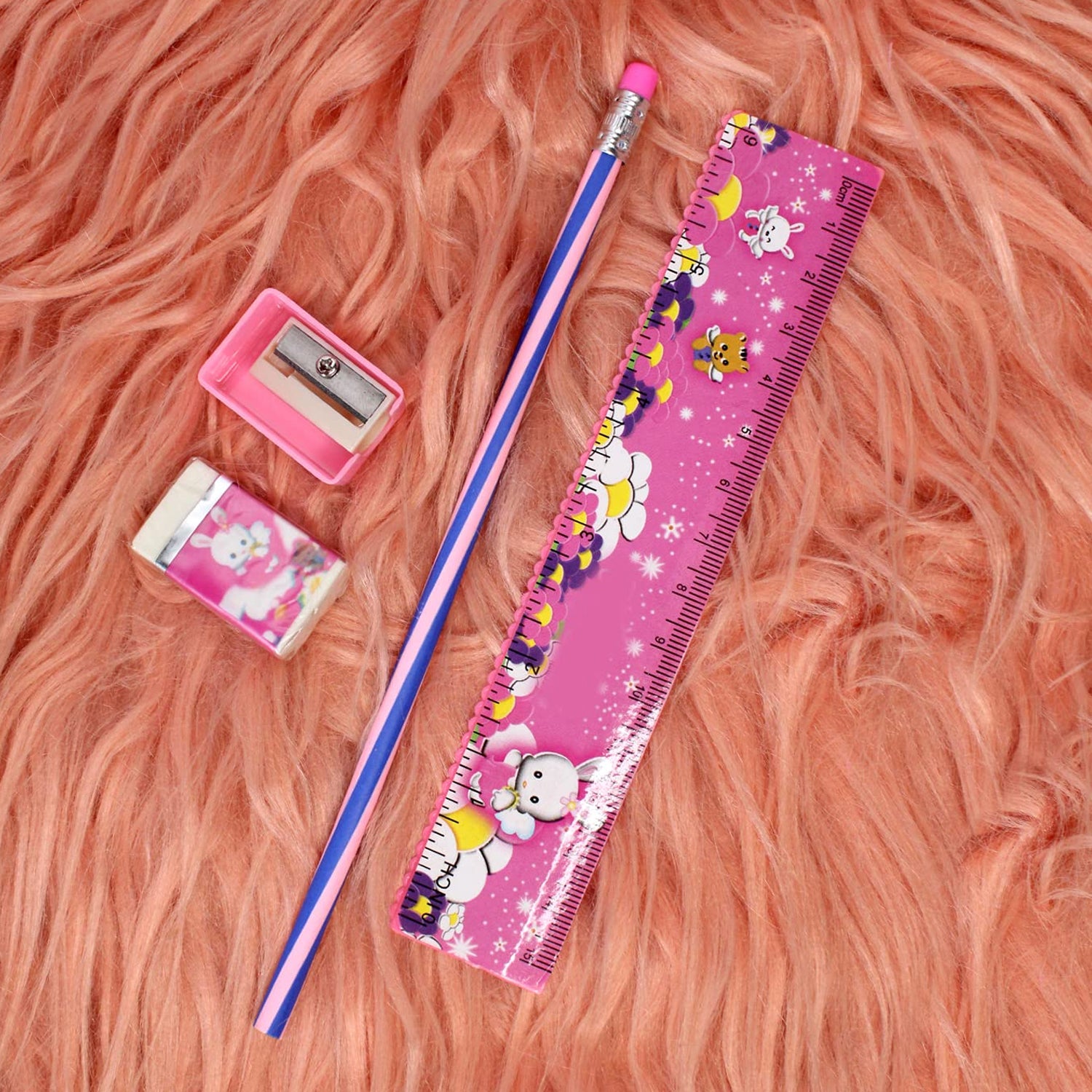 Wukusy 4-in-1 pink stationery set including ruler, pencil, eraser, and sharpener laid out on a white background.