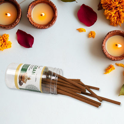 Wukusy Loban Dhoop sticks for home, religious ceremonies, meditation, and Pooja, 100g, with burning incense sticks in a traditional setting.