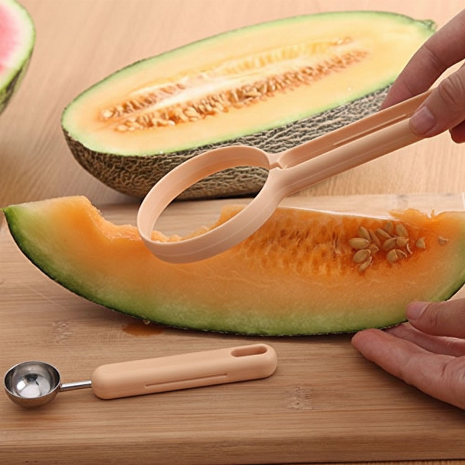 Wukusy 2-in-1 fruit scooper and cutter tool showing a stainless steel scoop and cutter blade in a hand.