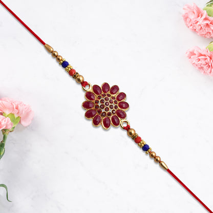 Red floral stone rakhi with bead accents, featuring intricate design and vibrant colors, by Wukusy for festive occasions.