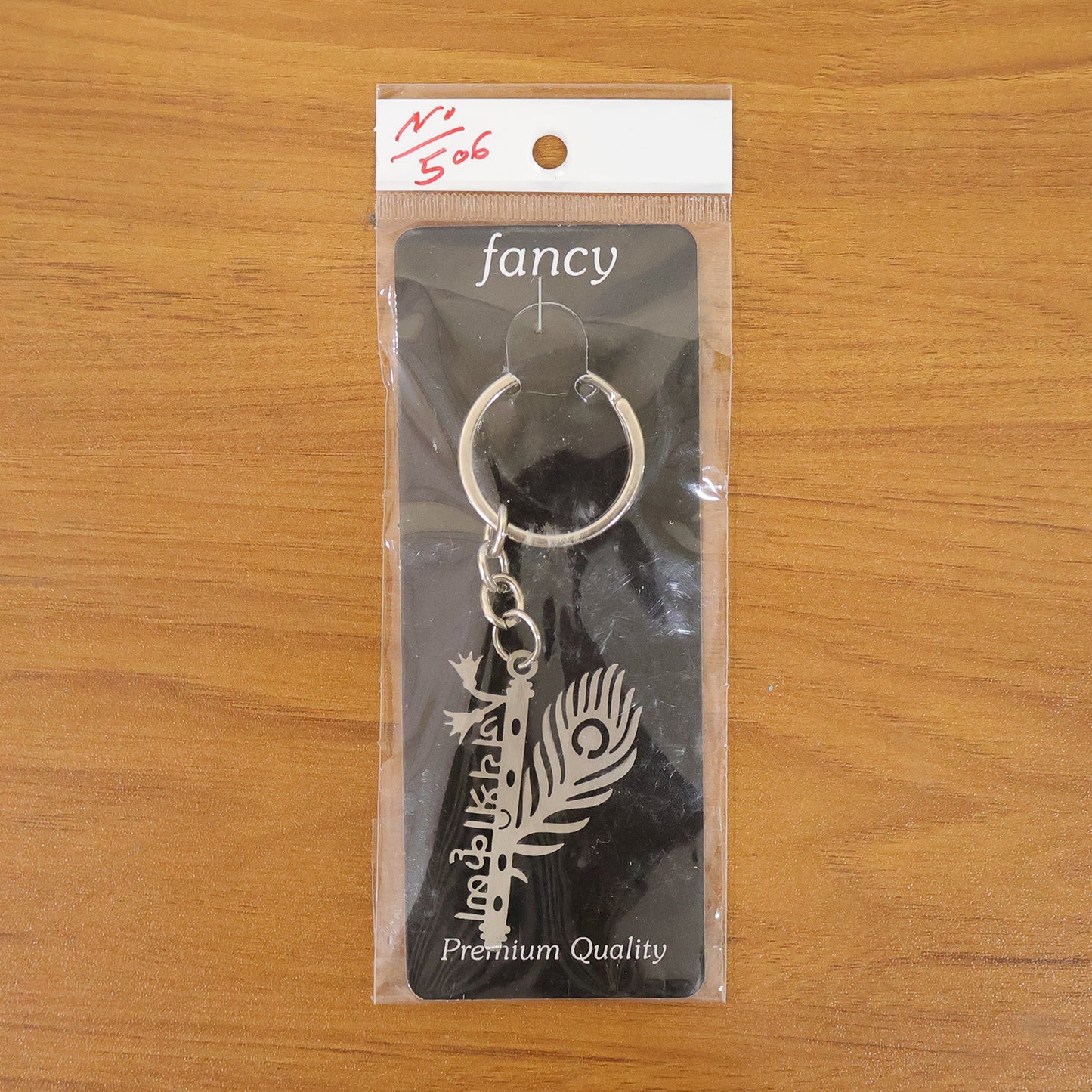 Wukusy premium metal Krishna flute keychain featuring intricate design and compact size on a plain background