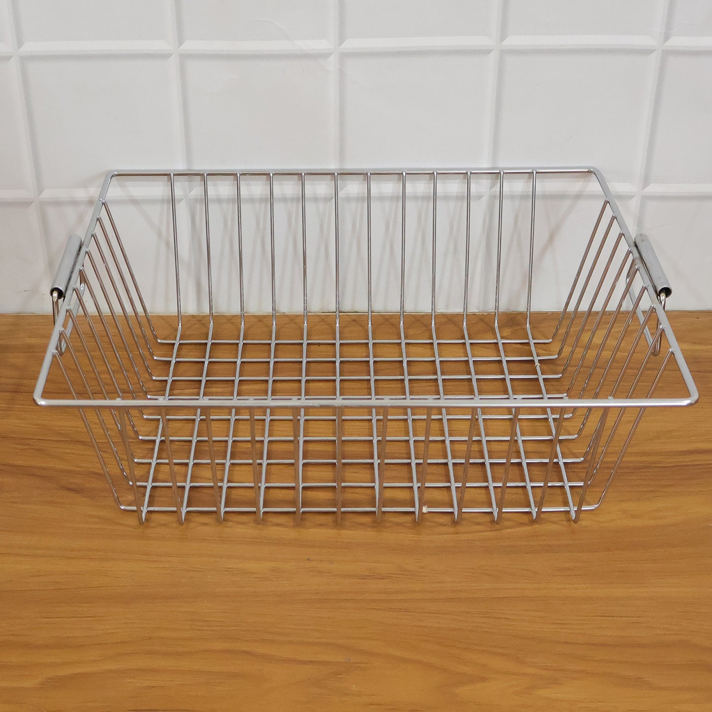 Wukusy stainless steel kitchen sink basket, 12x15 inch, used for draining and organizing utensils or produce in the sink.
