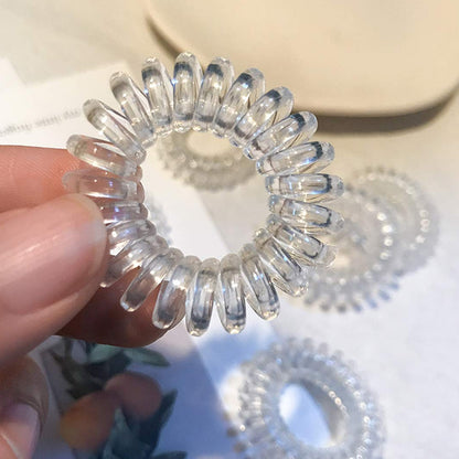 Set of three transparent spiral coil hair bands with cases from Wukusy, showcasing flexible, clear hair accessories on a white background.
