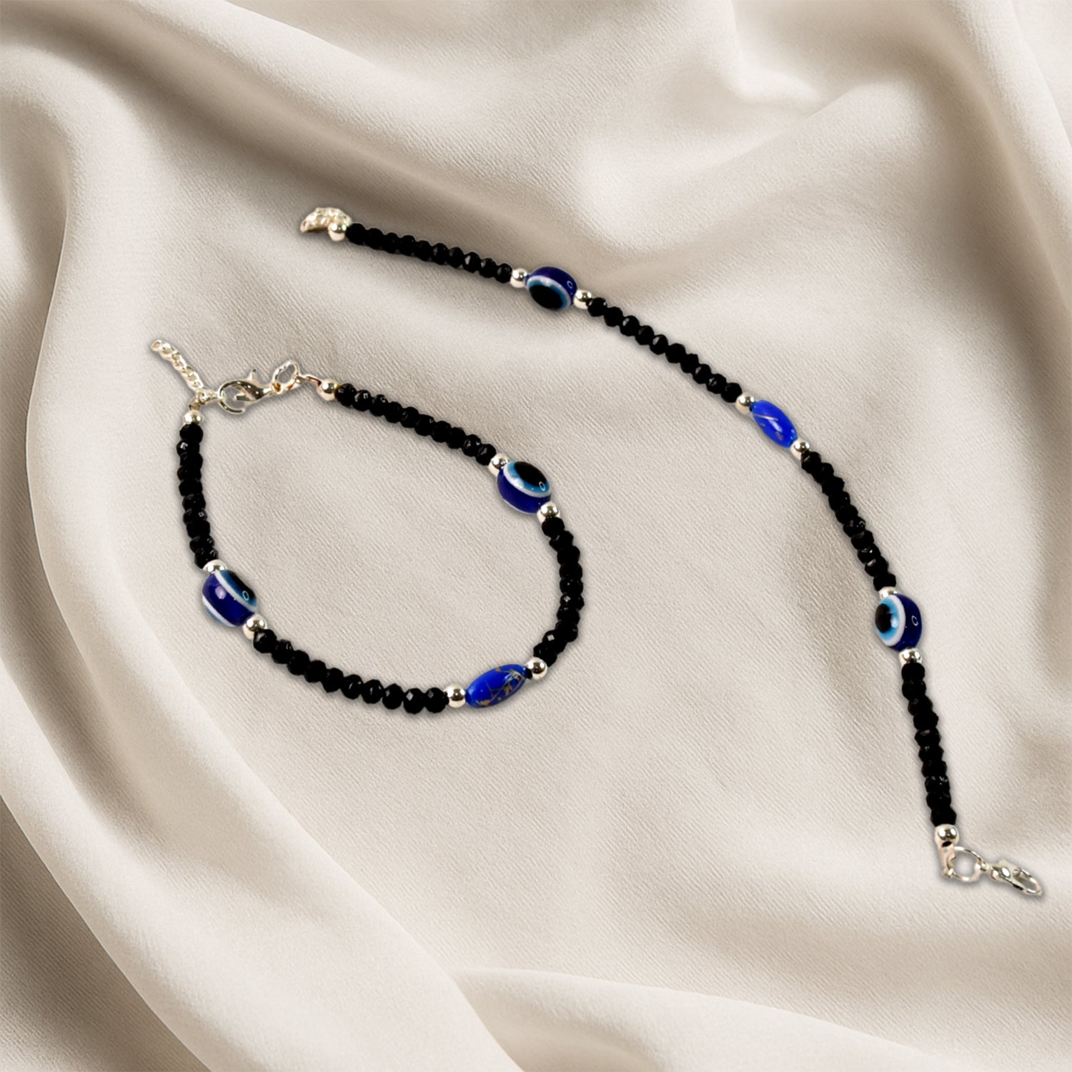Pair of black beaded evil eye protection bracelets with adjustable cords by Wukusy, featuring traditional blue eye charms.