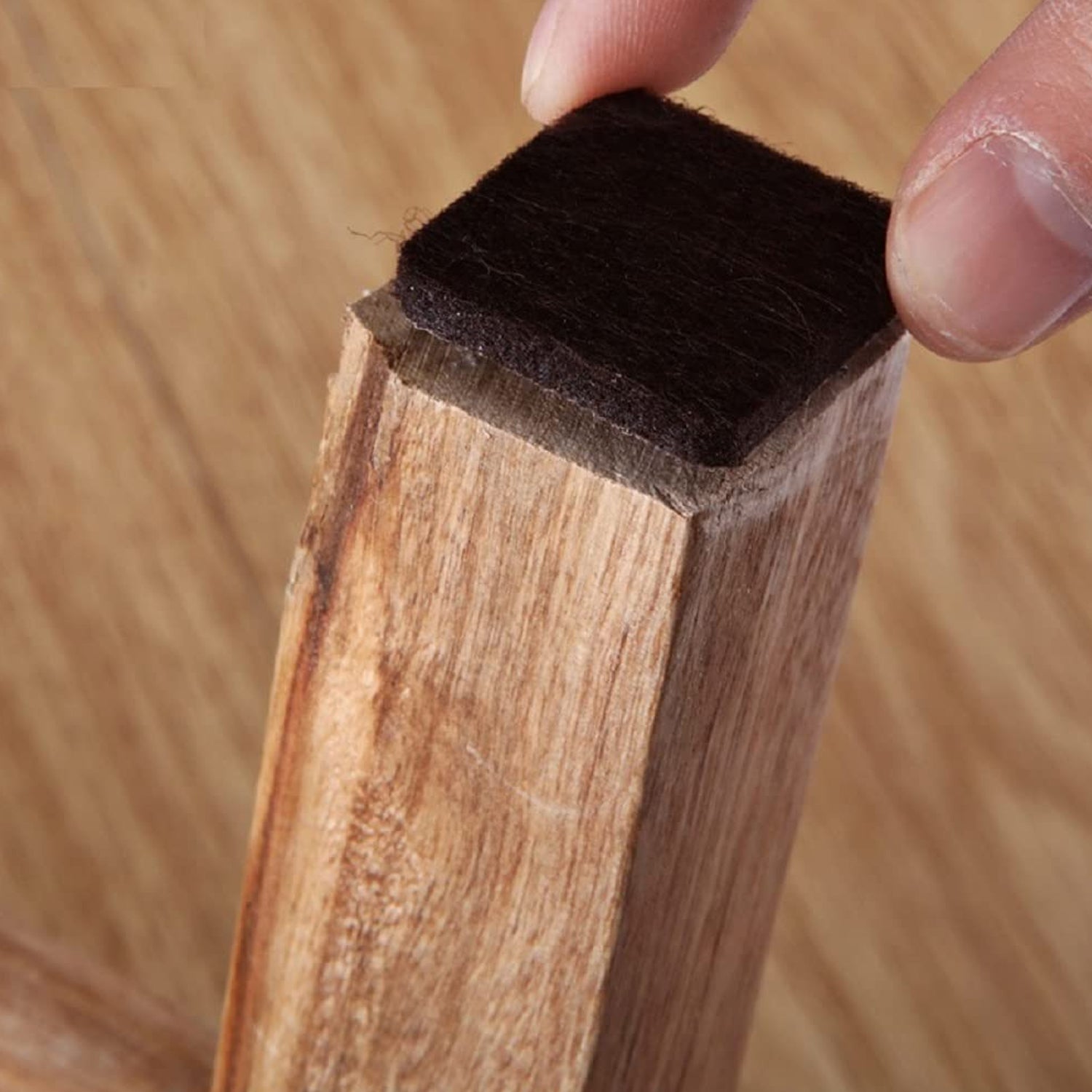 Square self-adhesive furniture feet pad by Wukusy for wardrobe and door furniture, shown attached to the bottom of a furniture piece.